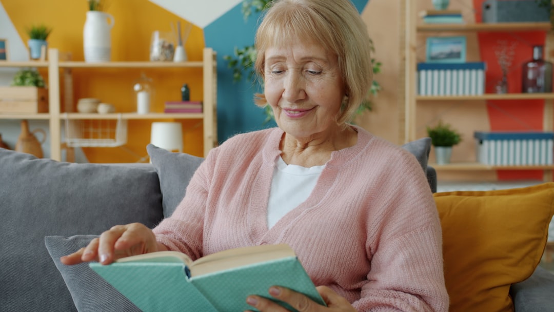 Elderly woman reading comfortably at home